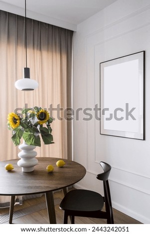 Vertical shot of wooden chair and dining table with lemons and yellow sunflowers in ceramic vase on kitchen. Cozy living room with home decor and copy space picture frame on white wall
