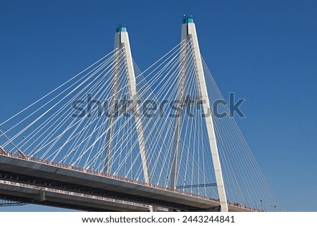 Guys and ropes against the blue sky, close-up. Engineering constructions of the cable-stayed bridge Royalty-Free Stock Photo #2443244841