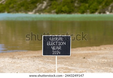 Global election year 2024 symbol. Concept words Global election year 2024 on beautiful black chalk blackboard. Beautiful mountain lake background. Business Global election year 2024 concept Copy space