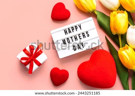 Happy Mother's Day. Lightbox with the word Happy Mother's Day, hearts and white and yellow tulips on pink background. Mother's day concept