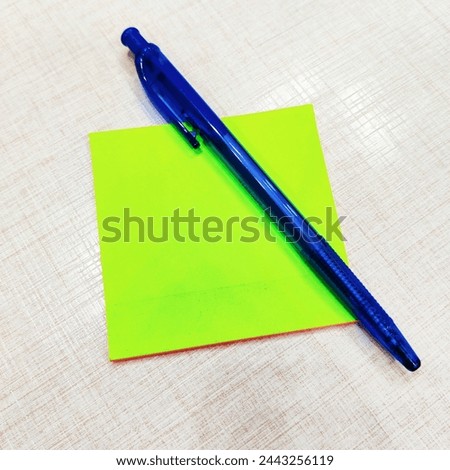 Blue pen on the green paper|Green paper|White background| Green paper with blue pen



