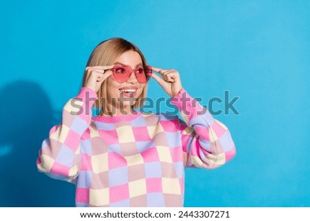 Photo portrait of pretty young girl touch sunglass celebrate look empty space wear trendy pink outfit isolated on blue color background