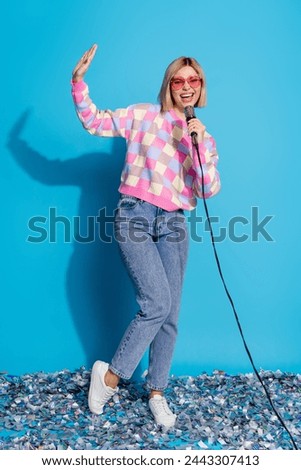Vertical photo of pretty young girl sunglass celebrate party karaoke confetti wear trendy pink outfit isolated on blue color background