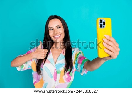 Photo of pretty young woman smart phone take selfie show thumb up wear shirt isolated on teal color background