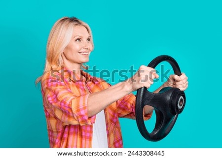 Photo of positive person with blond hair dressed checkered shirt hold steering wheel look empty space isolated on teal color background