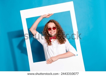 Photo portrait of nice young lady sunglass hold instant photo frame cheerful wear trendy white garment isolated on blue color background