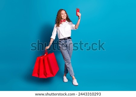 Photo portrait of pretty young woman take selfie shopping bags dressed stylish white clothes isolated on blue color background