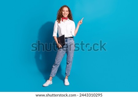 Photo portrait of pretty young woman point empty space netbook dressed stylish white clothes isolated on blue color background