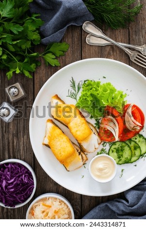 Seared halibut and fresh vegetables on wooden table 
