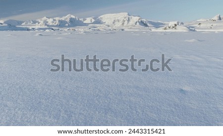 Panorama of scientific base in Infinitely, Infinitely polar snowy Antarctica desert. South Pole frost surface. Snow covered mountains on horizon. Aerial view flight. Ice Landscape. Winter frozen