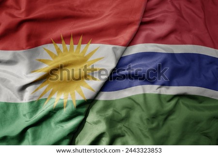 big waving national colorful flag of gambia and national flag of kurdistan. macro