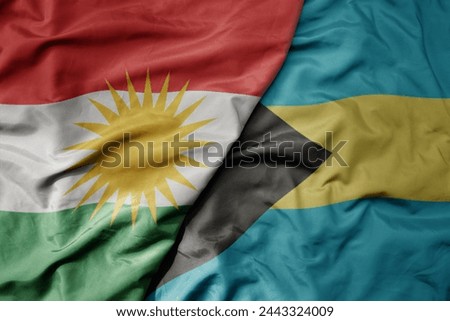 big waving national colorful flag of bahamas and national flag of kurdistan. macro