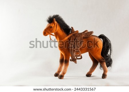 figurine of a toy plush horse with a saddle