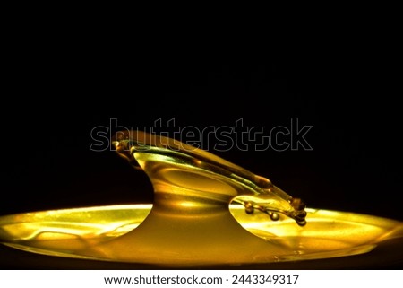 Close-up of water droplets falling instantly on a golden background