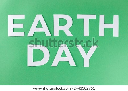 Earth Day Inscription with White Paper Letters on Green Background, Environmental Protection Concept