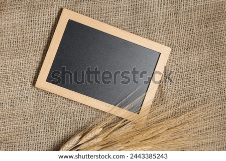 Chalkboard with wheat spikelets on burlap background
