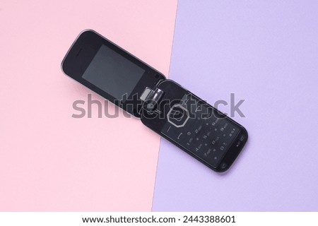 Retro flip mobile phone on pastel background