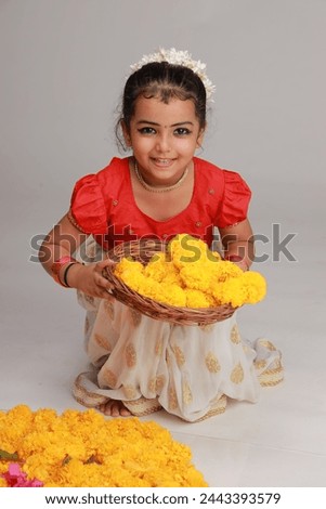 A cute small girl child wearing  Kerala dress-golden colour long skirt and red blouse,onam festival theme, isolated white background.