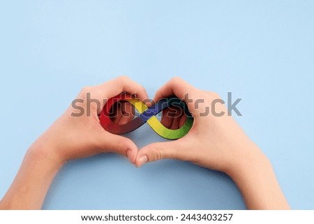 Autistic boy hands and rainbow eight infinity symbol. Autism awareness day symbol.