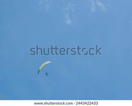 A paraglider on a sunny day Royalty-Free Stock Photo #2443422433