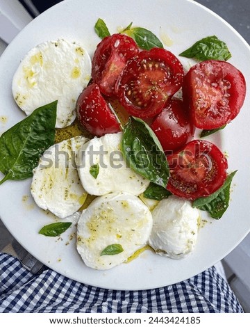 It seems like you might be referring to "Caprese salad." Caprese salad is a classic Italian dish made with fresh tomatoes, mozzarella cheese, basil leaves, olive oil, and balsamic vinegar. It's a simp Royalty-Free Stock Photo #2443424185