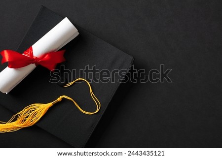 Flat lay composition with graduation hat and diploma on black background. Top view.