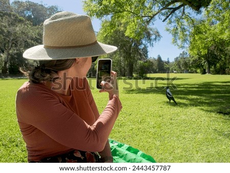 Girl takes a happy photo with her cell phone on a picnic.