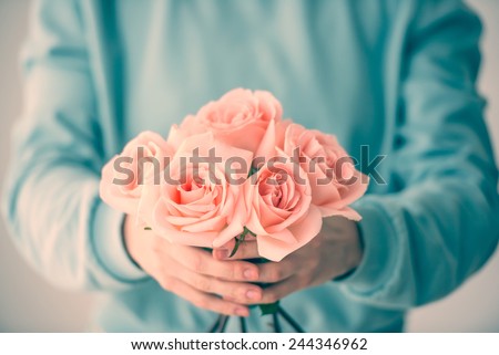 Hands holding bouquet of beautiful pink roses. Toned picture