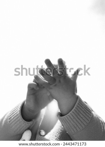 In this captivating photo, the innocence and purity of childhood are beautifully encapsulated in the intertwined hands of children. Against a backdrop of soft, natural light, these small hands tell a  Royalty-Free Stock Photo #2443471173
