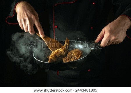 Preparing fried roach fish in the kitchen. Cook or fry fish in a frying pan in the hands of a chef. Delicious fish dish idea.