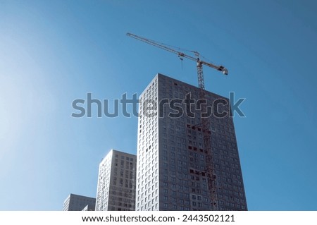 Modern skyscraper under construction with residential apartments, tower crane, new residential complex, urban city infrastructure, development business