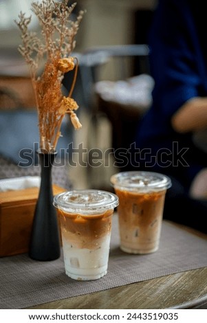 Two glasses of iced coffee on table in coffee shop.