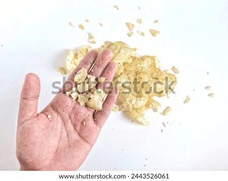 hand and potato chips isolated on white background. Dirty hands from holding scattered potato chips isolated on white.