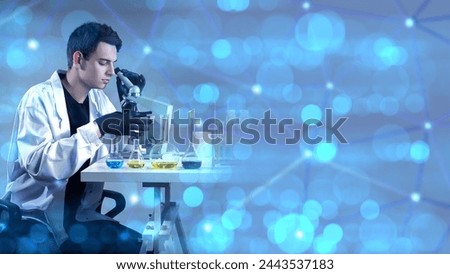 Man laboratory assistant. Guy with microscope. Laboratory technician conducts research. Scientist in white coat. Chemical laboratory employee. Man scientist sitting at table with reagents