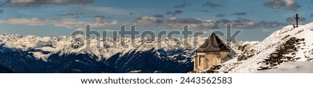 Winter view over the Alps and the epak from Mount Dobratsch, including the Windish Chapel and Mount Grossglockner at the horizon. Royalty-Free Stock Photo #2443562583
