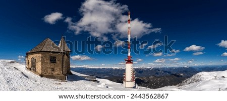 Winter view over Mount Dobratsch with the German Chapel, the summit hut and the 165m high Dobratsch Transmitter Tower. Royalty-Free Stock Photo #2443562867