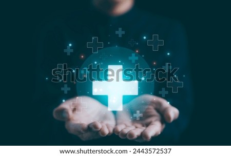 Businessman holding virtual blue plus sign for positive thinking mindset or healthcare insurance symbol concept for mental rejuvenation. Business value added. increase investment growth, benefits add, Royalty-Free Stock Photo #2443572537