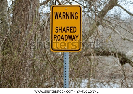 A sign warning pedestrians of the shared roadway.