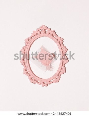 Tuft of pastel pink faux fur through the hole wallpaper, oval baroque frame, creative decoration, girly aesthetic.
