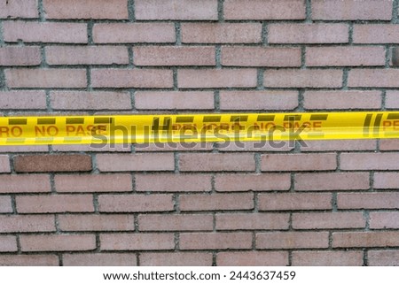 Danger: Cordoned Brick Wall with Yellow Warning Band.  Warning message in Spanish: "Peligro, no pase"