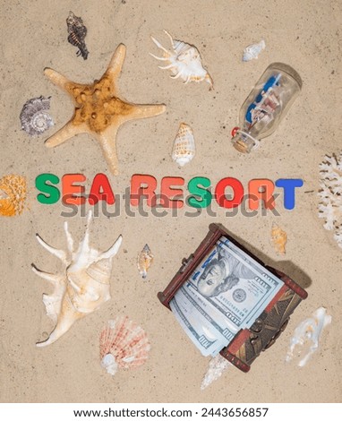 Money for vacation, rest, holiday, dream, travel. A well-deserved vacation at an expensive seaside resort. Chest with dollars on the beach. The inscription in on the sand "Sea Resort" Royalty-Free Stock Photo #2443656857