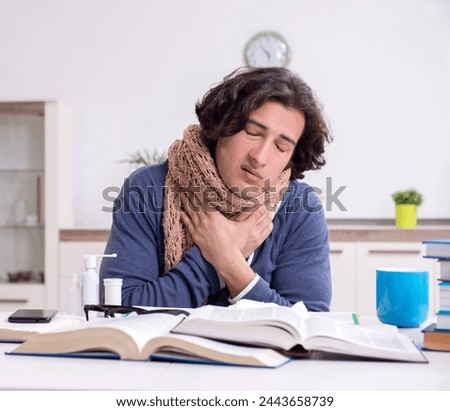 Sick male student suffering at home Royalty-Free Stock Photo #2443658739