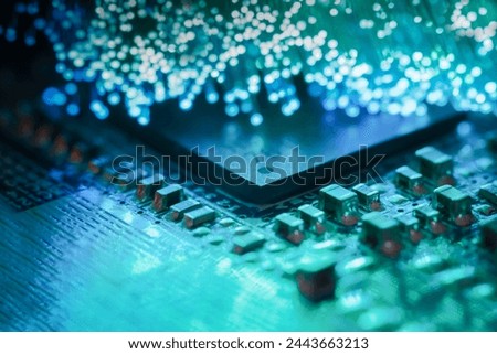 Macro photograph of a printed circuit board with a processor and optical fibers illuminating the board Royalty-Free Stock Photo #2443663213