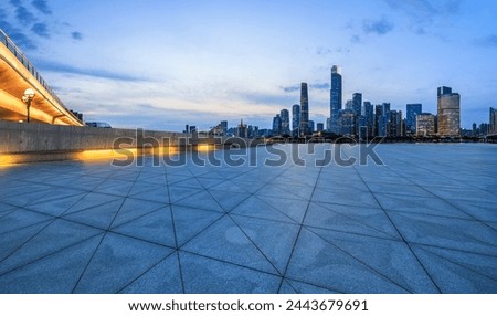 Empty square floors and city skyline with modern buildings at dusk in Guangzhou. Panoramic view.