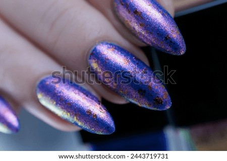 Female hand with long nails and a blue lilac color nail polish