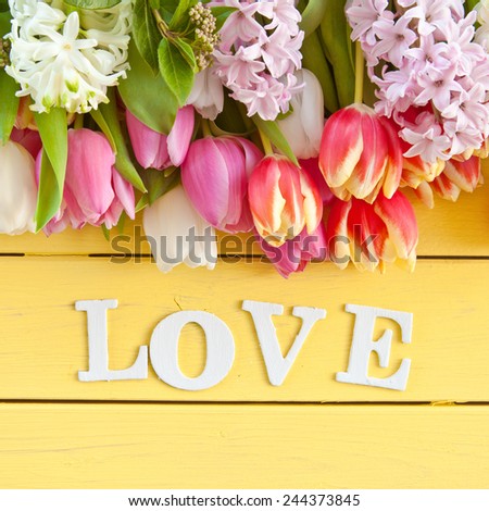 Colorful spring flowers on yellow wooden boards