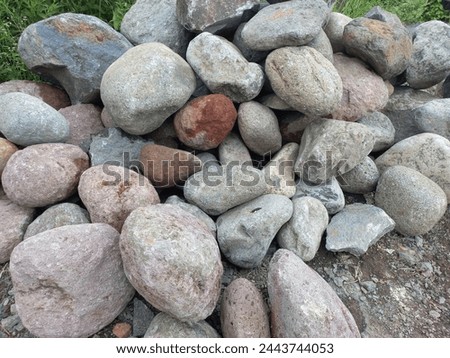 a pile of large river stones that are still intact on the side of the road Royalty-Free Stock Photo #2443744053