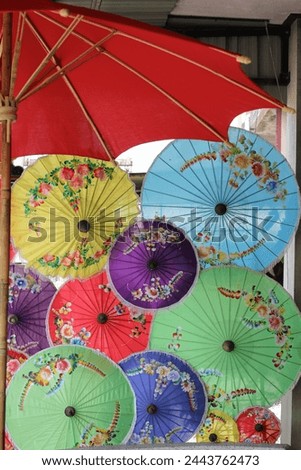 Picture many size the Umbrella colorful by have a beautiful paint flower show on . It work handicraft in Cheng Mai city , This picture can use for background . 