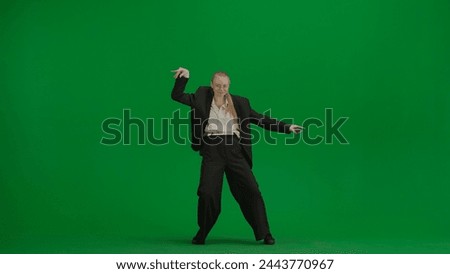 Woman in black business suit dancing cheerfully on green screen with chromakey.