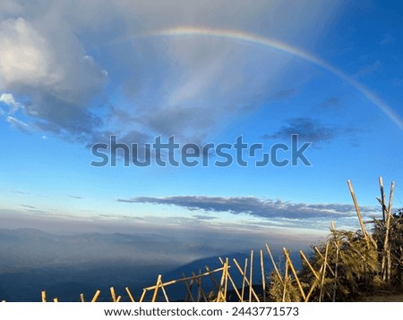Picture on a mountain with a view of the sky with a rainbow